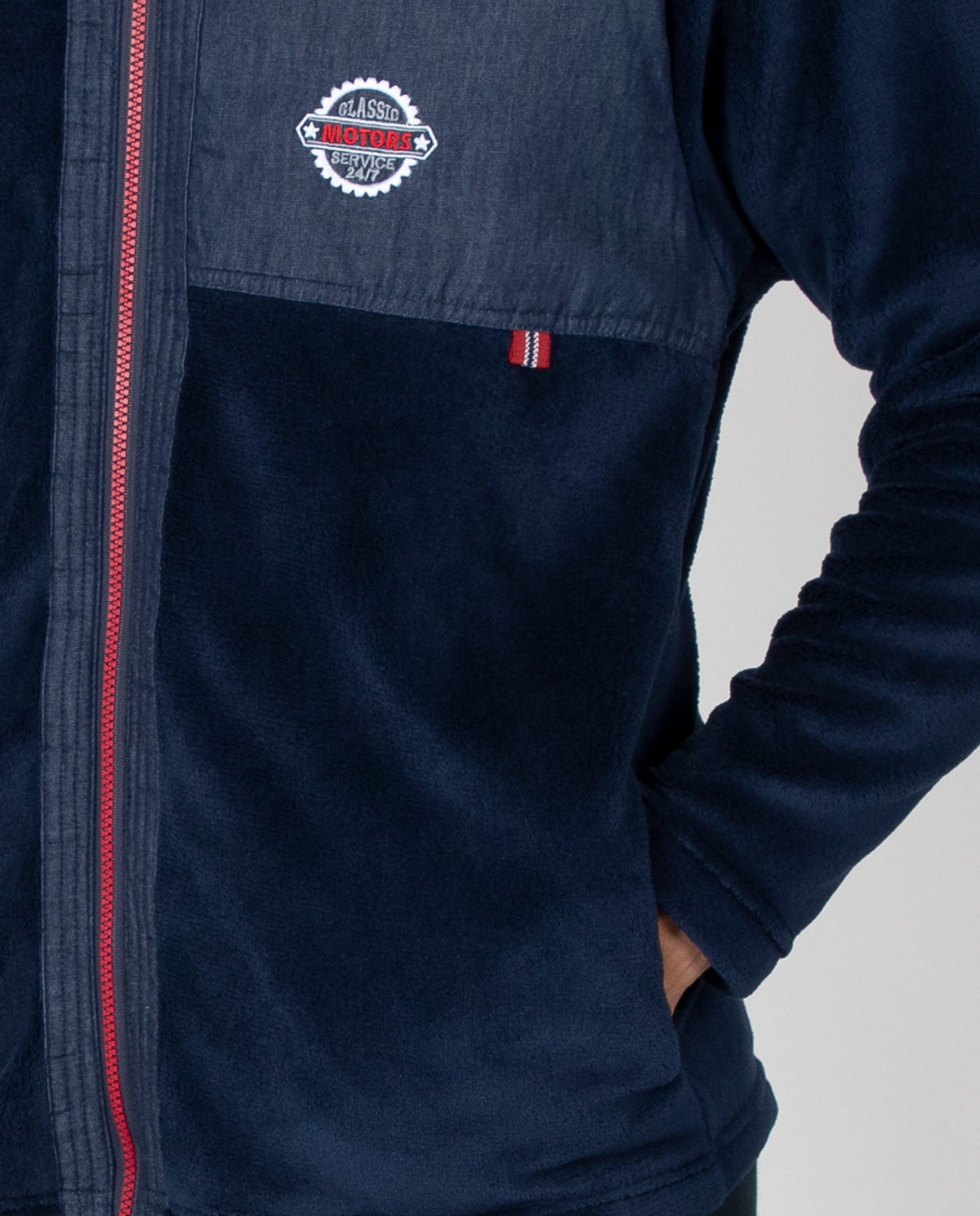 Bata corta de hombre en tejido polar liso con cremallera a contraste, detalle bordado y bolsillos la
